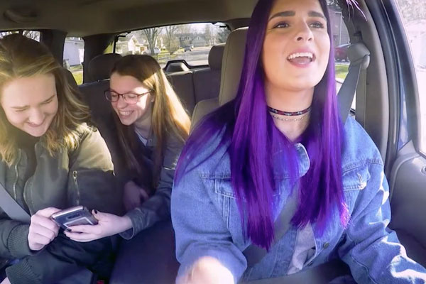 three teen girls in a car talking
