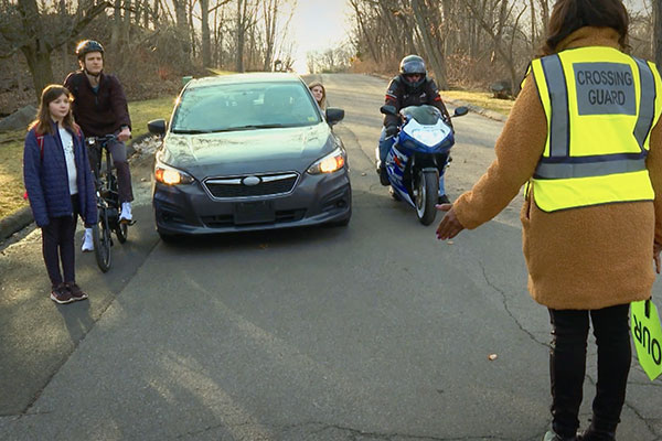 crossing guard with people who use the road