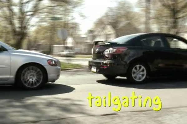 one car tailgating another with a chyron that reads "Tailgating"
