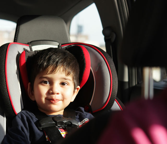 a young child in a carseat in the back of a car