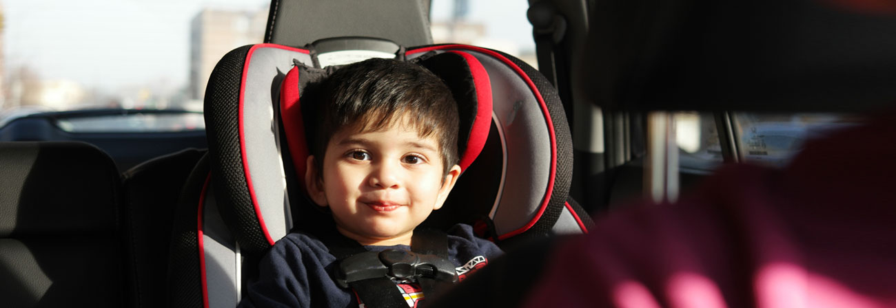 a young child in a carseat in the back of a car