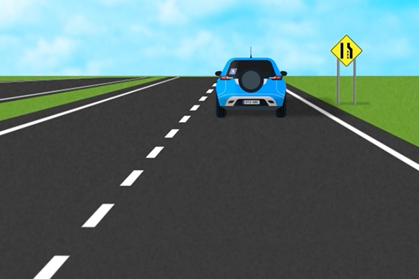car on a road coming up to a zipper merge sign