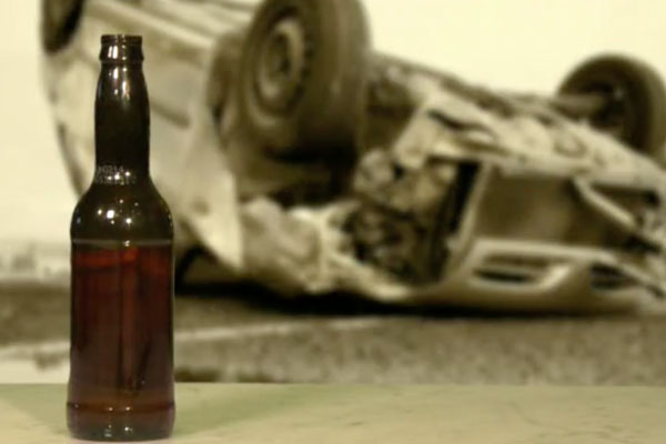 car overturned with a beer bottle in the foreground