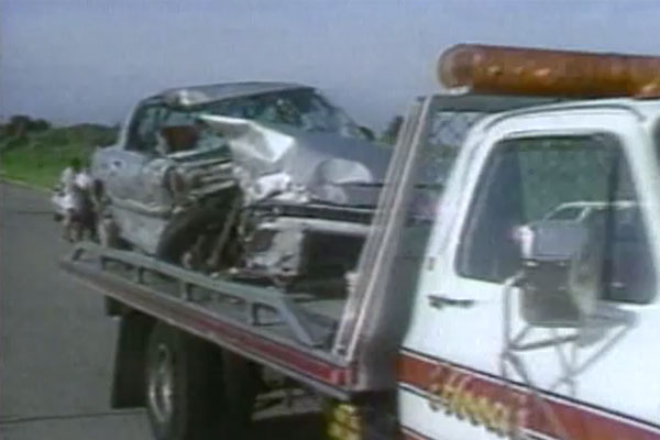 a platform tow-truck carrying a crashed car