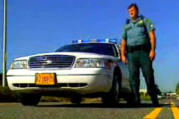 a policeman and his car on a road